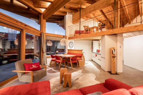 a living room with a red couch and a table at Löwen Chalets in Seefeld in Tirol