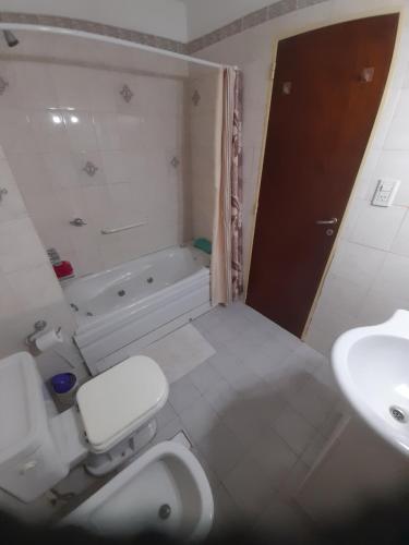 a bathroom with a toilet and a sink and a tub at Sueños del Golfo in Puerto Madryn