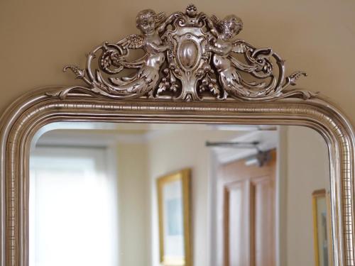 an ornate gold frame on a mirror in a bathroom at The Old Manse Pickering in Pickering