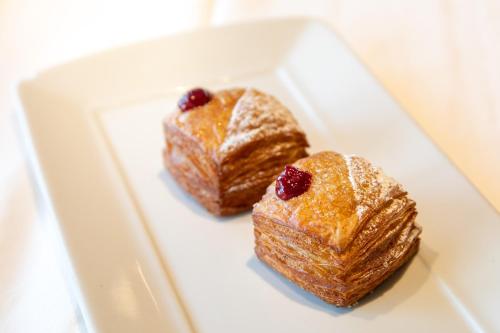 two pastries on a white plate on a table at Cormoran Residence in Villasimius