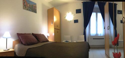 a bedroom with a large bed and a window at L'Appart in Bonifacio