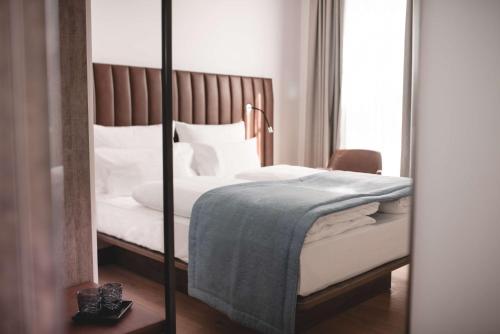 a bedroom with a bed with a mirror at Aiden by Best Western Biberach in Biberach an der Riß