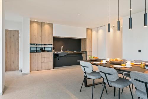 a kitchen and dining room with a table and chairs at Eb in De Panne