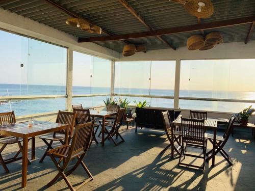 a restaurant with tables and chairs and a view of the ocean at Manhatã Hostel in Salvador