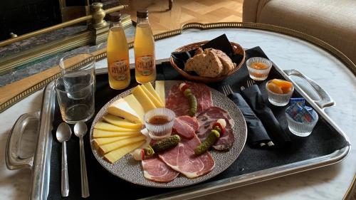 a tray of food with meat and cheese and drinks at Villa Victor Louis - Bordeaux Centre in Bordeaux