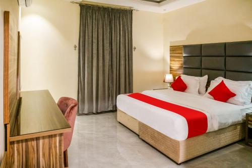 a hotel room with a bed with red pillows at درة ترف 2 للشقق المفروشة المخدمة Durra Taraf Residential 2 in Dammam