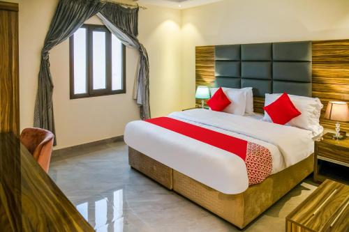 a bedroom with a large bed with red pillows at Durra Taraf Residential 2 in Dammam