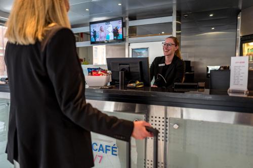 a woman is standing at a cash register at Cabinn City in Copenhagen