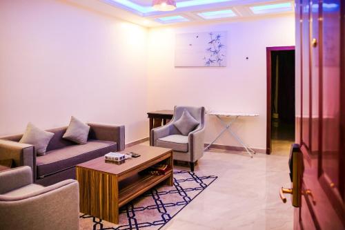 a living room with a couch and chairs and a table at درة ترف 2 للشقق المفروشة المخدمة Durra Taraf Residential 2 in Dammam