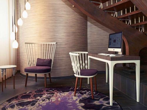 two chairs and a desk with a computer on it at Mercure Toulouse Centre Wilson Capitole in Toulouse