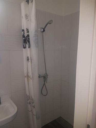 a shower with a shower curtain in a bathroom at Napfény Szállás in Szeged