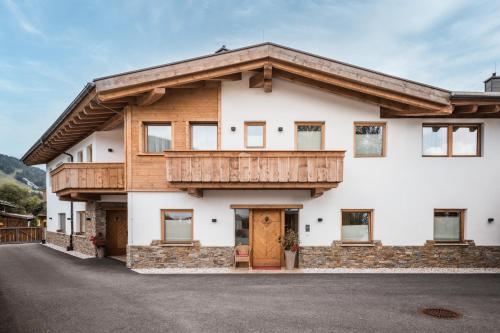 a large white house with a wooden roof at Löwen Chalets in Seefeld in Tirol