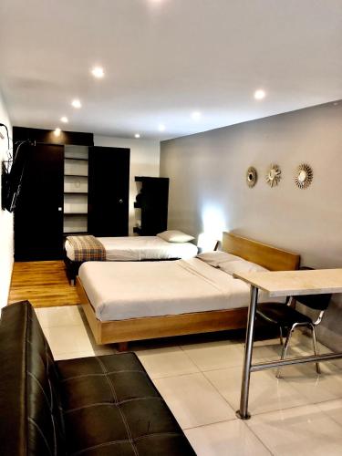 a hotel room with two beds and a couch at Bogotá Rooms Heroes in Bogotá