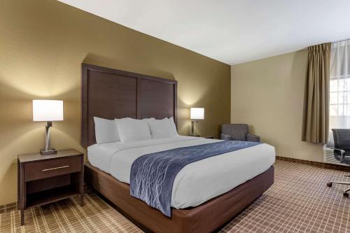 a hotel room with a large bed and a chair at Comfort Inn St Robert-Fort Leonard Wood in Saint Robert