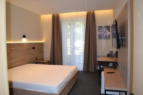 a bedroom with a bed and a desk and a window at Sport Hotel 1 in Cherkasy