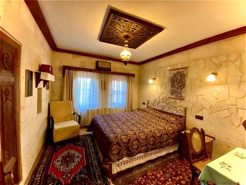 a bedroom with a bed and a stone wall at Sofa Hotel in Avanos