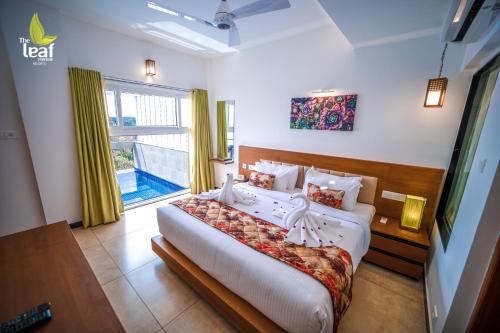 - une chambre avec un grand lit et une grande fenêtre dans l'établissement The Leaf Munnar, à Munnar
