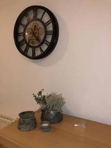 a clock on a wall above a wooden table at Chalet Albatros in Diever