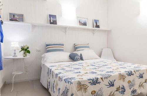 a bedroom with a bed with a blue and white blanket at Pochi Passi dal Mare in San Bartolomeo al Mare
