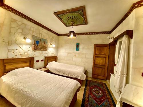 a bedroom with two beds and a window at Sofa Hotel in Avanos