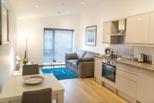 a kitchen and living room with a couch and a table at Citystay Living - Franklin House in Cambridge