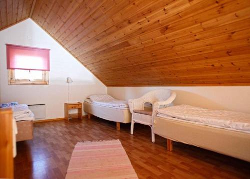 エッケローにあるMarbyfjärden seaside village Loftetの木製の天井が特徴のベッドルーム1室(ベッド2台付)