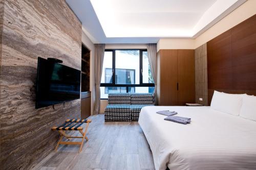 a hotel room with a large bed and a tv at Hu Shan Hot Spring Hotel in Taian