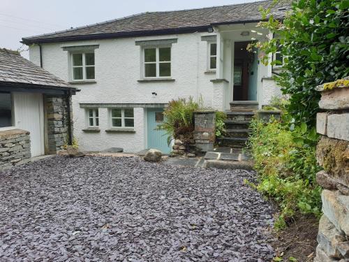 a house with a gravel driveway in front of it at Barn End in Elterwater