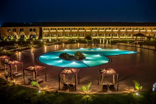 a hotel with a large swimming pool at night at Hawthorn Suites by Wyndham Dwarka in Dwarka