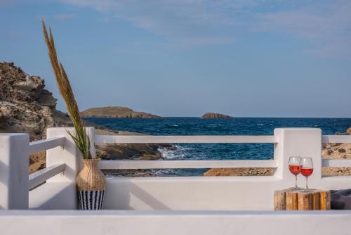 a glass of wine sitting on a white ledge overlooking the ocean at AQUA HOUSE in Pachaina