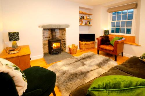 a living room with a fireplace and a couch at Juniper Cottage, Chapel Stile, Langdale in Chapel Stile