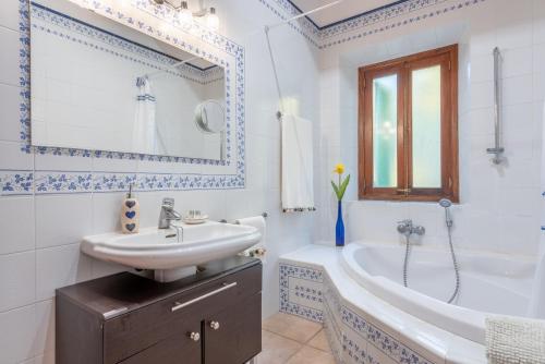 a white bathroom with a sink and a tub and a sink at SA VOLTA DE C'AN OLIVER in Deia