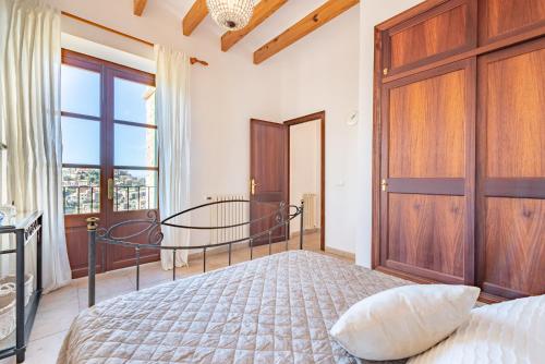 a bedroom with a bed and a wooden door at SA VOLTA DE C'AN OLIVER in Deia