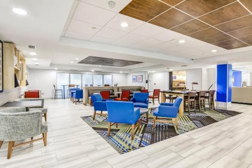 a waiting room with blue chairs and tables at Holiday Inn Express & Suites Longview North by IHG in Longview