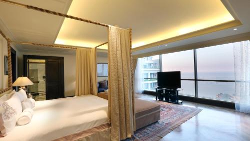 a bedroom with a canopy bed and a television at InterContinental Phoenicia Beirut by IHG in Beirut