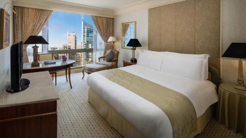 a hotel room with a bed and a desk and a window at InterContinental Phoenicia Beirut by IHG in Beirut