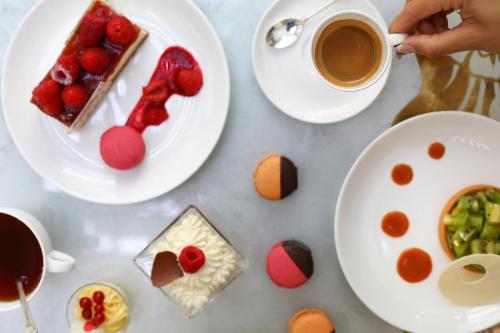 a table with plates of food and a cup of coffee at InterContinental Phoenicia Beirut by IHG in Beirut