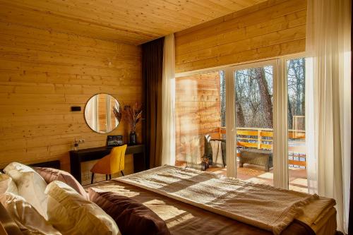 a bedroom with a large bed and a large window at Garden Hotel and Spa in Cheboksary