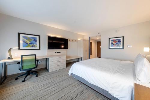 a hotel room with a bed and a desk with a computer at Holiday Inn Express & Suites - Staunton by IHG in Staunton