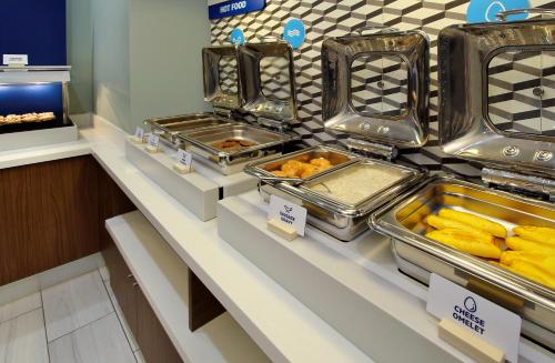 a buffet line with trays of food on display at Holiday Inn Express & Suites - Dallas Market Center by IHG in Dallas