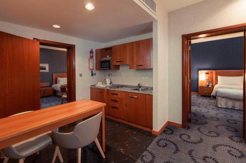 a hotel room with a kitchen and a bedroom at Holiday Inn - Suites Kuwait Salmiya by IHG in Kuwait
