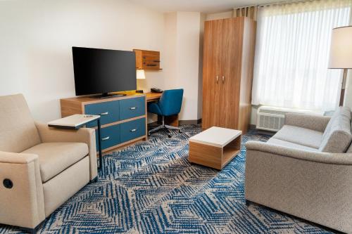 a living room with two chairs and a tv in a hotel room at Candlewood Suites - Las Vegas - E Tropicana by IHG in Las Vegas