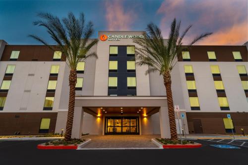 a hotel with two palm trees in front of it at Candlewood Suites - Las Vegas - E Tropicana by IHG in Las Vegas