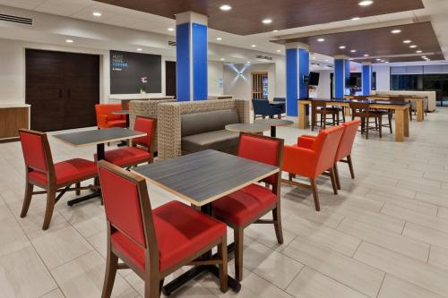 - un restaurant avec des tables, des chaises et un canapé dans l'établissement Holiday Inn Express & Suites - Fayetteville, an IHG Hotel, à Fayetteville