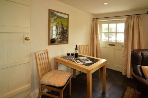 a room with a table and a chair and a window at Fold Cottage, Outgate near Ambleside in Hawkshead