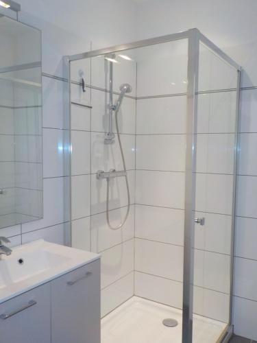 baño con ducha y puerta de cristal en Appartements Candella, en Galeria