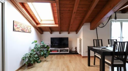 ein Wohnzimmer mit einem TV und einem Esstisch in der Unterkunft Italianway - Colombo 4 in Villasanta