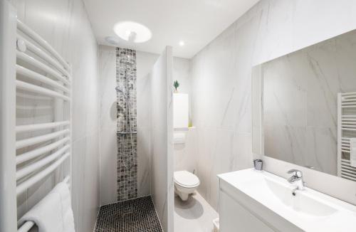 une salle de bain blanche avec des toilettes et un lavabo dans l'établissement Résidence Petra d'Oro - Villa Chiappa, à Porto-Vecchio