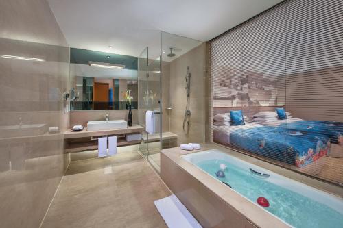 a bathroom with a tub and a bed and a sink at Crowne Plaza Beijing Sun Palace by IHG in Beijing