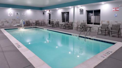 a large swimming pool with chairs and tables at Holiday Inn Express & Suites Lexington Midtown - I-75 by IHG in Lexington